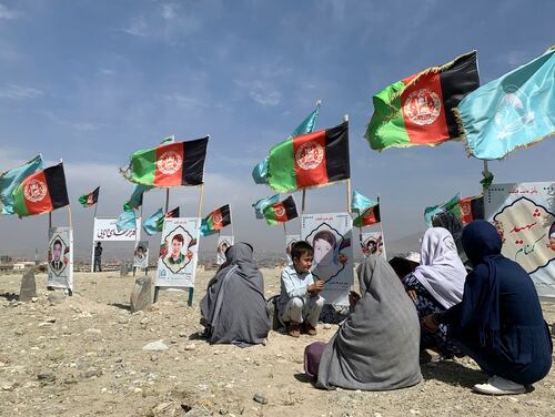 In this Sept 14, 2020, file photo, families and friends of students who were killed in local conflicts gather at the graves of their relatives, adorned with their pictures, on the outskirts of Kabul, Afghanistan. (Rahmat Gul/AP)