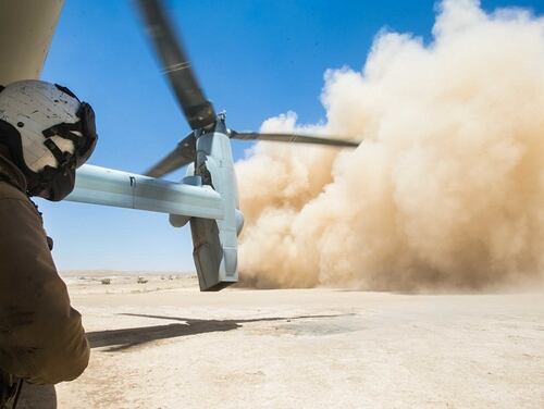 A U.S. Marine Corps crew chief observes an MV-22B Osprey land during a resupply mission in support of Combined Joint Task Force – Operation Inherent Resolve (CJTF-OIR) at Firebase Um Jorais, Iraq, June 27. (Cpl. Jered T. Stone/Marine Corps)
