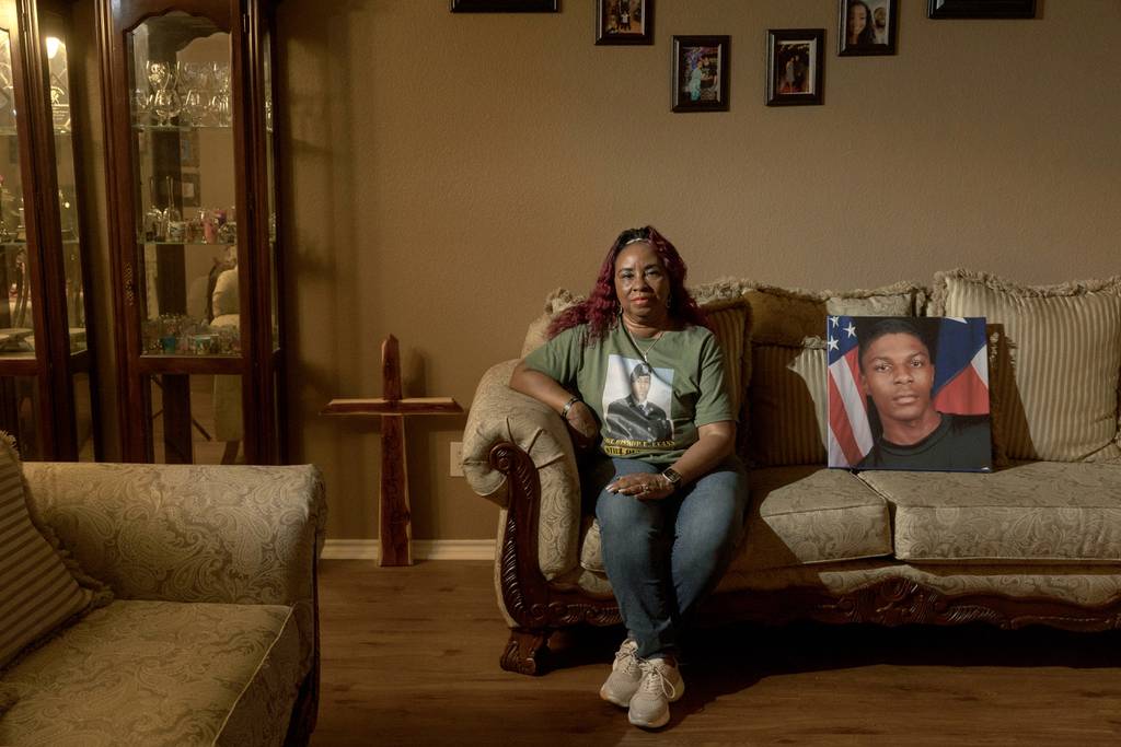 Jo Ann Johnson sits for a portrait with a photo of her grandson, Bishop Evans, in her home in Arlington, TX on December 7, 2022.