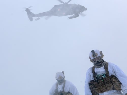 Paratroopers from the 25th Infantry Division, U.S. Army Alaska, look away from a landing UH-60 helicopter during medical evacuation training at Joint Base Elmendorf-Richardson, Alaska, Feb. 20. (Sgt. Alex Skripnichuk/Army)