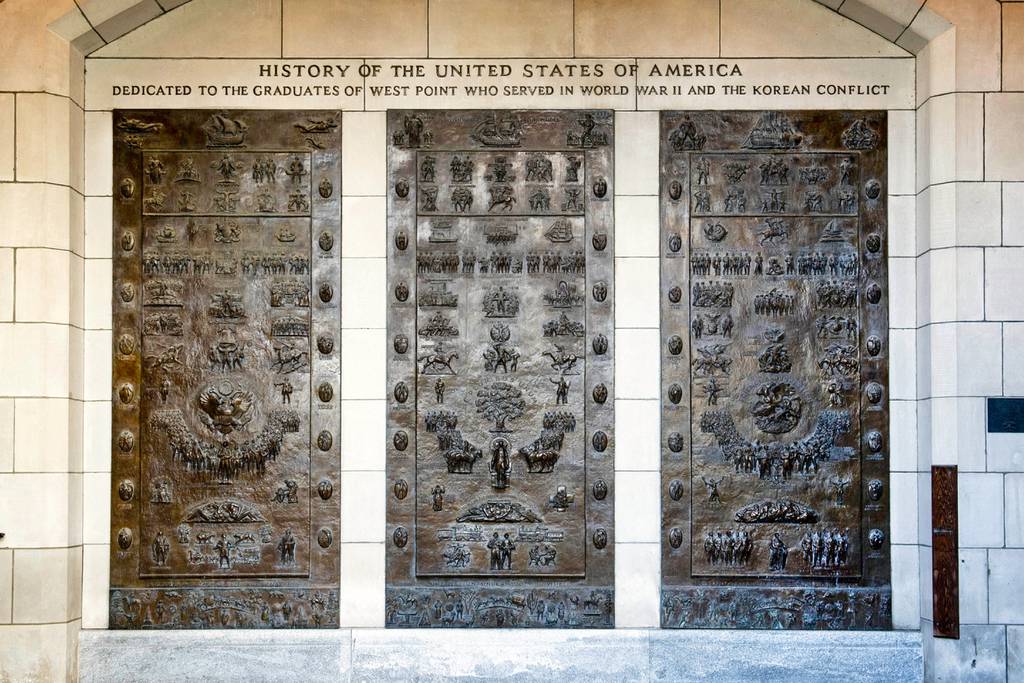This photo provided by the U.S. Military Academy at West Point in New York shows the three bronze panels at one of the entrances to Bartlett Hall, at West Point, that depicts the history of the United States.