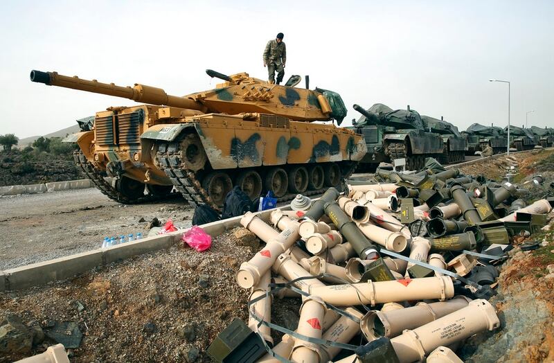 In this Jan. 22, 2018, file photo, Turkish soldiers prepare their tanks next to empty shells at a staging area on the outskirts of the village of Sugedigi, Turkey, on the border with Syria. (Lefteris Pitarakis/AP)