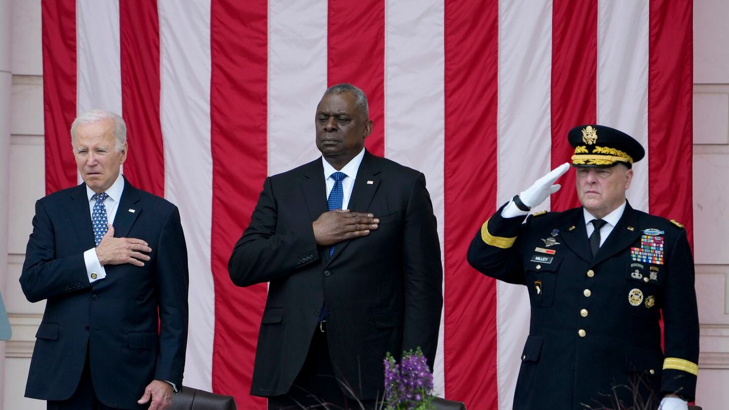 President Joe Biden holds his hand on his heart as he stands with Defense Secretary Lloyd Austin and Chairman of the Joint Chiefs of Staff Gen. Mark Milley during the playing of 
