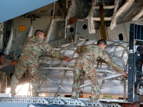 US soldiers load a C-17 cargo plane with food, water and medicine for a humanitarian mission to Venezuela, at Homestead Air Force Base in Homestead, Florida, on February 22, 2019. (RHONA WISE/AFP/Getty Images)