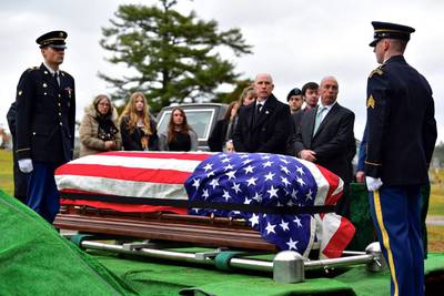 Family members surround the casket of Army Sgt. Alfred Sidney at his burial service in Littleton, N.H., on Thursday, Dec. 8, 2022.