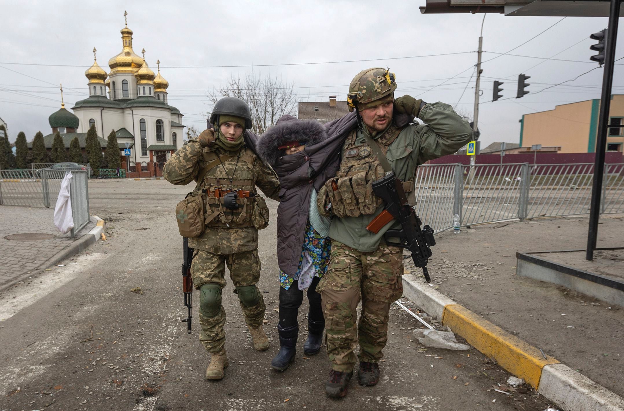 Ukrainian servicemen help an elderly woman, in the town of Irpin, Ukraine, Sunday, March 6, 2022. (Andriy Dubchak/AP)