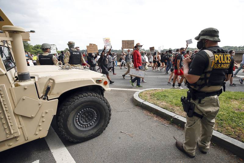 DC National Guard soldiers and other law enforcement personnel watch as demonstrators protest Saturday, June 6, 2020, along Independence Avenue in Washington, over the death of George Floyd, a black man who was in police custody in Minneapolis.