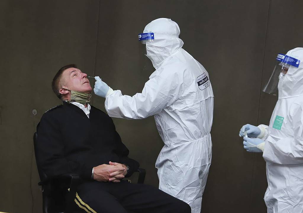 In this photo released by the Royal Thai Army, a health officer collects a nasal swab sample from Gen. James McConville, chief of staff of the U.S. Army, to test for the coronavirus at the military airport in Bangkok on July 9, 2020.