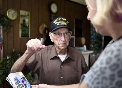 Ernest Marvel, WWII Army Veteran, shows off photos from a party Aug. 2, 2022, in Frankford, Del.
