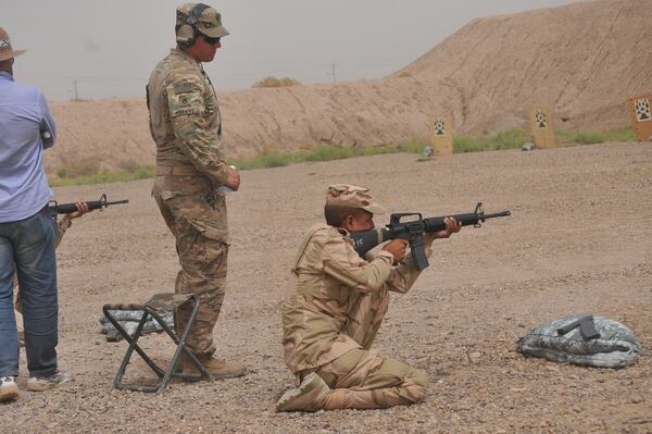 U.S. Army Staff Sgt. William Meravy, left, a trainer with Company A, 1st Battalion 502nd Infantry Regiment, Task Force Strike, watches as an Iraqi army ranger student engages targets in the kneeling position at Camp Taji, Iraq July 3, 2016,. To pass the qualification event, the students had to score based on U.S. Army marksmanship standards. Camp Taji is one of four Combined Joint Task Force – Operation Inherent Resolve building partner capacity locations dedicated to training Iraqi security forces. (U.S. Army photo by 1st Lt. Daniel Johnson/Released)