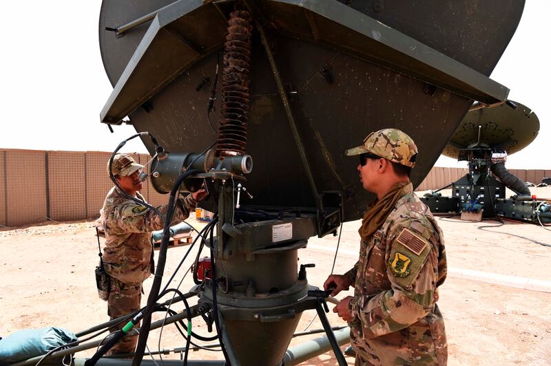 Air Force communications airmen conduct maintenance on one of the satellite dishes housed at Nigerien Air Base 201 in September 2017 in Agadez. (Staff Sgt. Joshua Dewberry/Air Force)