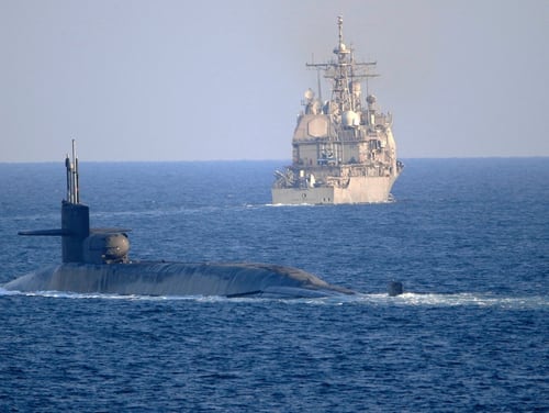 The guided-missile submarine USS Georgia, front, with the guided-missile cruiser USS Port Royal, transits the Strait of Hormuz in the Persian Gulf on Dec. 21, 2020. (MC2 Indra Beaufort/U.S. Navy via AP)