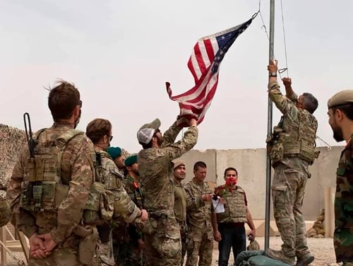A U.S. flag is lowered as American and Afghan soldiers attend a handover ceremony from the U.S. Army to the Afghan National Army, at Camp Antonik, in Helmand province, southern Afghanistan, Sunday, May 2, 2021. (Afghan Ministry of Defense Press Office via AP)