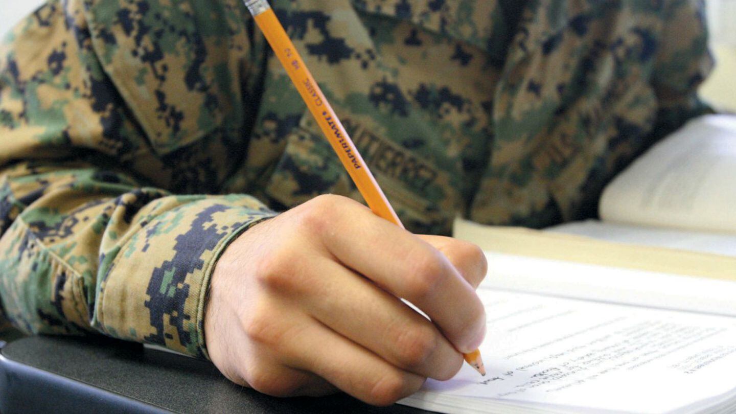 Cpl. Angelo Gutierrez, Headquarters company, 3rd Marines, works out of his textbook during a MASP class in classroom D, at the Joint Education Center here Nov. 19. (U.S. Marine Corps photo by Lance Cpl. Ronald Stauffer/Released)
