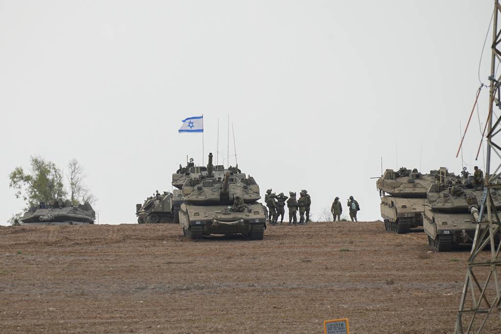 Israeli soldiers are seen in a staging ground near the Israeli Gaza border, southern Israel, Monday, Oct. 9, 2023.