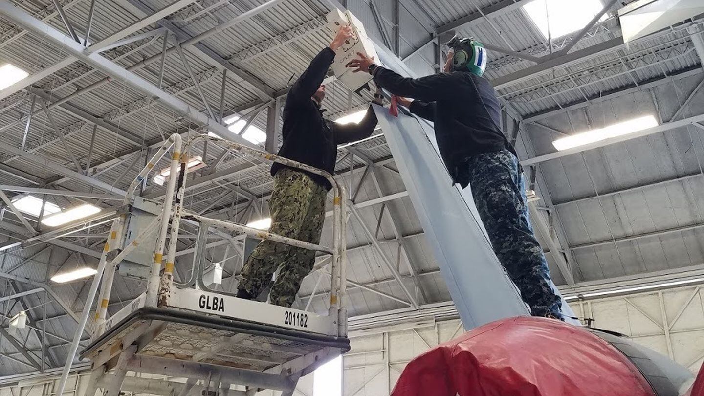 Two fleet technicians attach ALR-67 test equipment onto an F/A-18 aircraft at Naval Air Station Lemoore, Calif., on Feb. 14, 2019. (Chief Aviation Machinist's Mate Alvin Zuilan/U.S. Navy)
