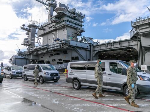 A sailor from the carrier Theodore Roosevelt, seen here portside in Guam, was found unresponsive Thursday morning after testing positive 10 days ago for COVID-19. (MCC Matthew White/Navy)