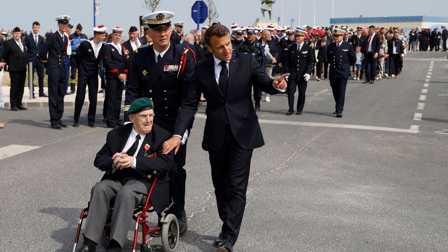 FILE - French President Emmanuel Macron speaks with Leon Gautier, a French WWII veteran of the Commando Kieffer, during a ceremony in tribute to the 177 French members of the 