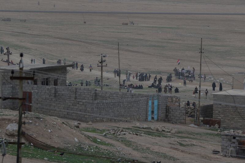 Iraqi security forces distribute food to refugees from Badush outside of a patrol base near Al Tarab, Iraq, during the offensive to liberate West Mosul from ISIS, on March 10, 2017. (Army)