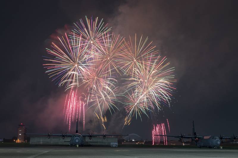 Fireworks explode behind a C-130J Super Hercules during Celebrate America at Yokota Air Base, Japan, July 3, 2019.