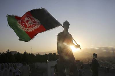 In this Aug. 19, 2019, file photo, a man waves an Afghan national flag during Independence Day celebrations in Kabul, Afghanistan