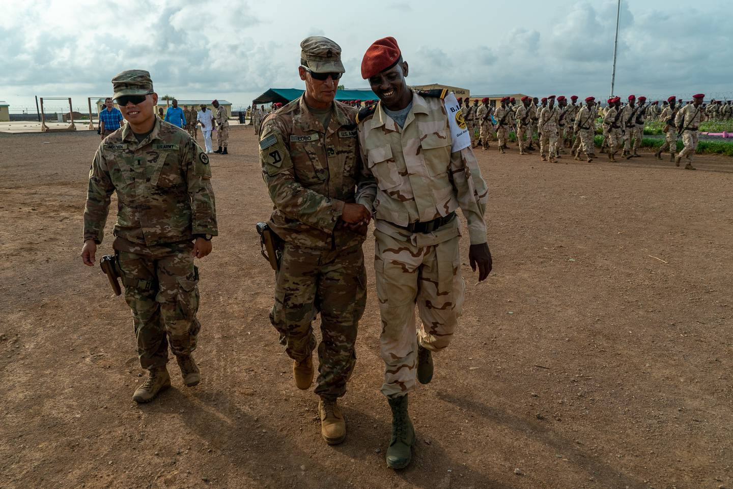 Army Sgt. 1st Class Hercules Lobo (right) and 1st Lt. Dui Nguyen congratulate a soldier assigned to Djibouti’s Rapid Intervention Battalion during a ceremony in Ali Oune, Djibouti, June 6, 2019.