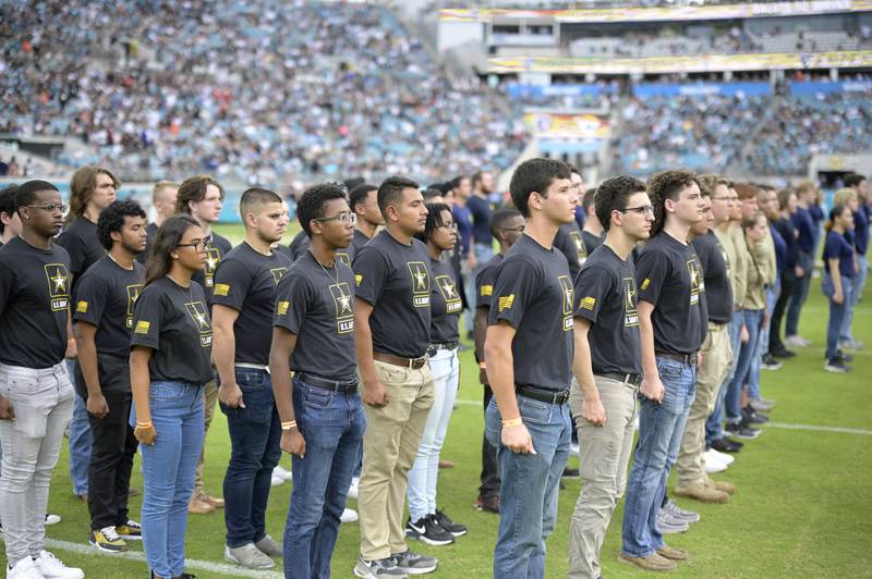 Military recruits are sworn in during halftime on Salute to Service military appreciation day at an NFL football game between the Jacksonville Jaguars and the Las Vegas Raiders, Nov. 6, 2022, in Jacksonville, Fla.
