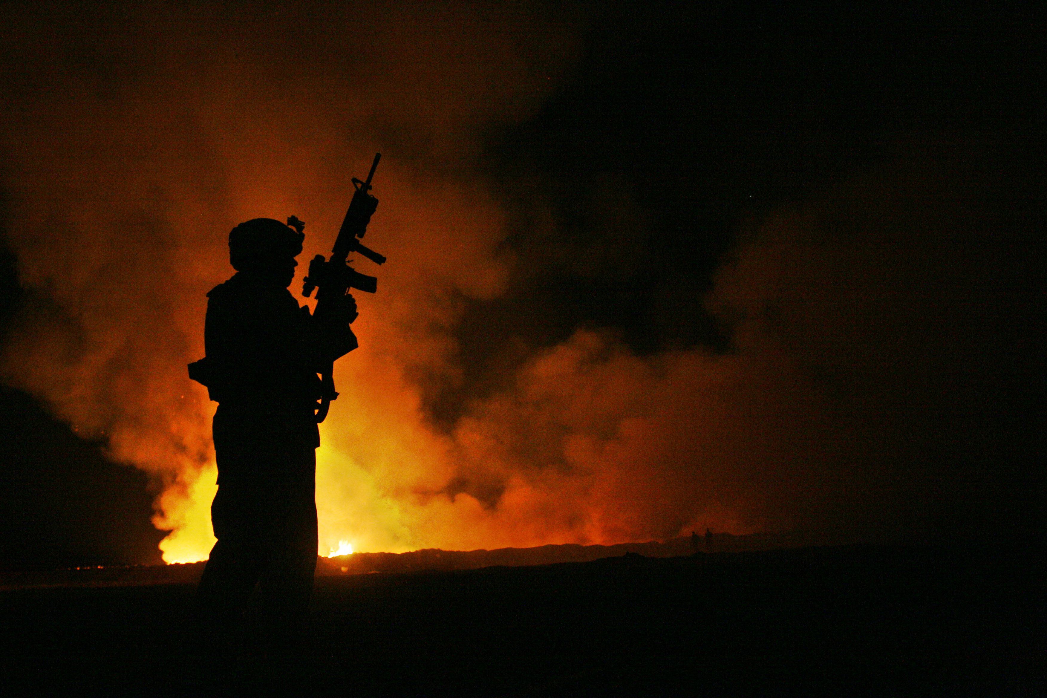 Sgt. Robert Brown watches over workers at a burn pit in Iraq on May 25, 2007. (Cpl. Samuel D. Corum/Marine Corps)