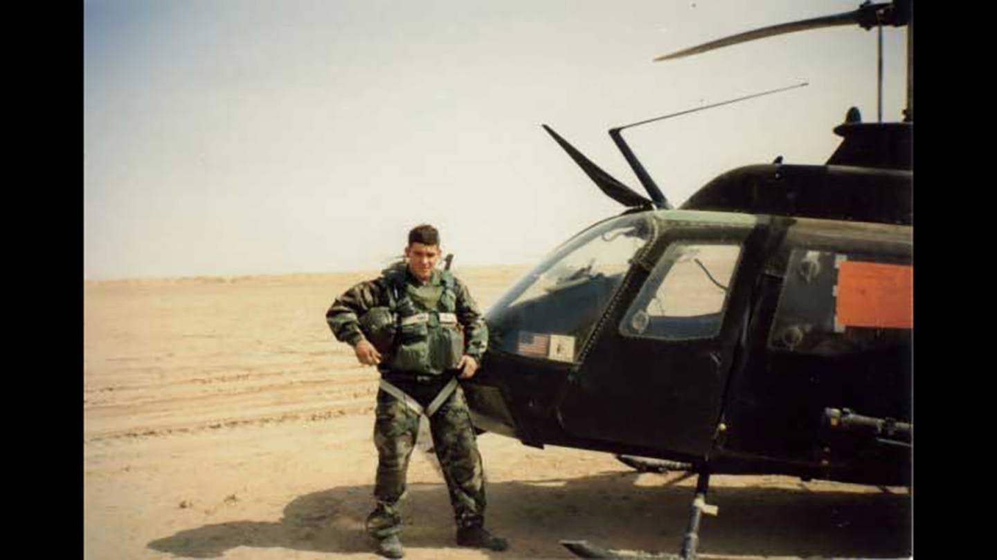 Fred Wellman stands next to his Kiowa OH-58C, The Mad Penguin, in Iraq.