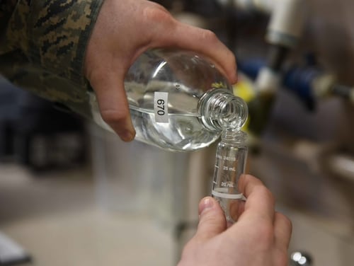 A water and fuels system maintenance technician pours water into a small vial to test the chlorine, fluoride and pH levels. (Airman 1st Class Erin McClellan/Air Force)