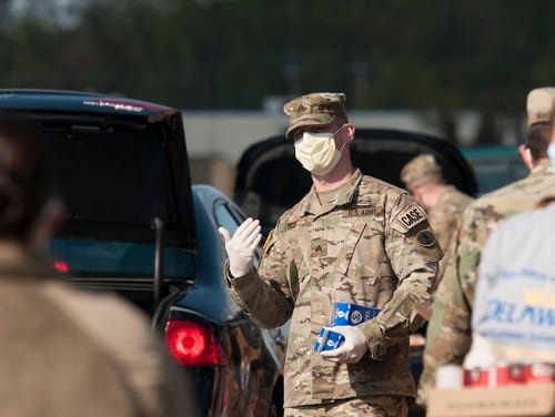 Sgt. Joshua Scott, a soldier with the Delaware Army National Guard's 153rd Military Police Company, directs traffic at a drive-thru mobile pantry on the grounds of the Dover International Speedway in Dover, Del., on April 22, 2020. (Capt. Brendan Mackie/Army National Guard)