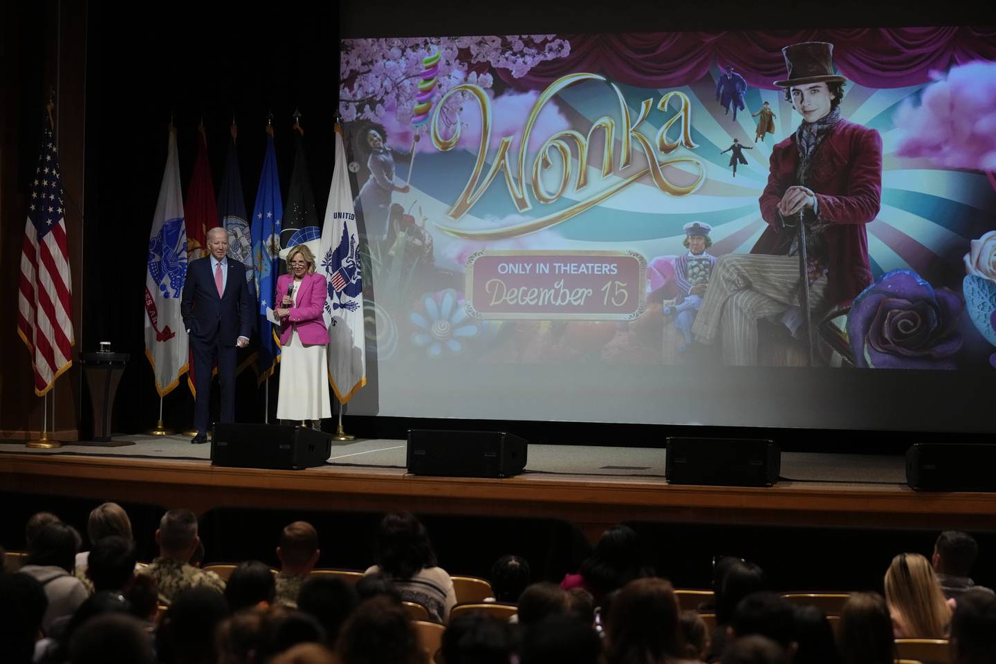 President Joe Biden listen as first lady Jill Biden speaks before a screening of the movie "Wonka" in Norfolk, Va., Sunday, Nov. 19, 2023.
