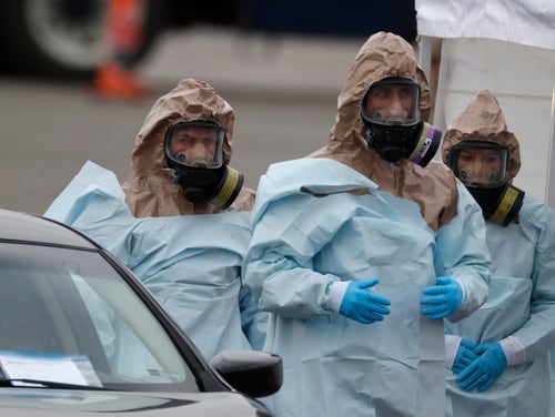 Colorado National Guard medical personnel prepare to perform coronavirus test on a motorist at a drive-through testing site outside the Denver Coliseum on Saturday in Denver. (David Zalubowski/AP)