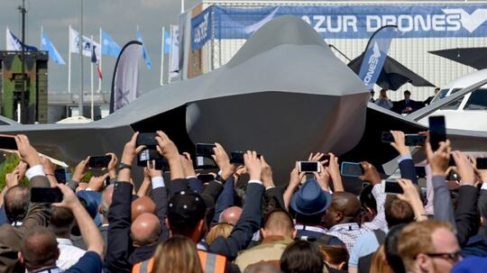 Visitors attend the unveiling ceremony of the full-scale jet fighter model of the French-German-Spanish new-generation Future Combat Air System at the 2019 Paris Air Show. (Eric Piermont/AFP via Getty Images)