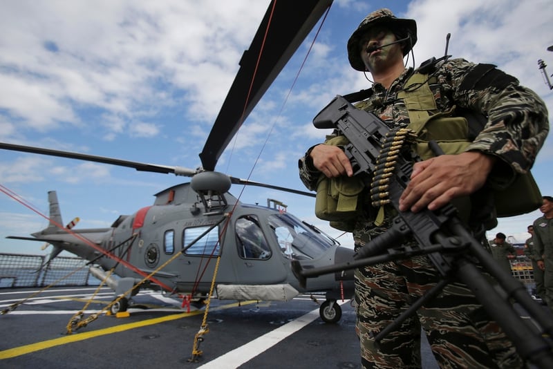 A Filipino special operator stands beside a Philippine Navy helicopter on board the Gregorio Del Pilar warship in Manilla in December 2014. The Philippines is trying to modernize its navy amid tensions with China over the disputed Spratly Islands in the South China Sea. (Aaron Favila/AP)