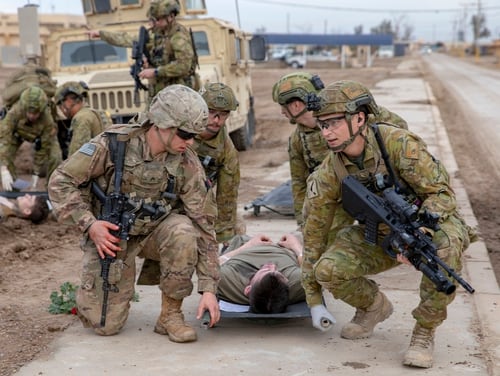 A U.S. soldier, left, and Australian soldiers carry a simulated casualty on a Talon Litter during a mass casualty training exercise at Camp Taji, Iraq, Feb. 1, 2020. (Spc. Caroline Schofer/Army)