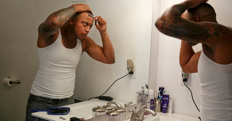 Petty Officer 2nd Class Taryn McLean looks in the mirror. Taryn was born female but identifies as male. He was among 11,000 transgender active duty and reserve troops that the RAND Corp. estimated are serving in the armed forces. (Kristen Zeis/The Virginian-Pilot via AP)