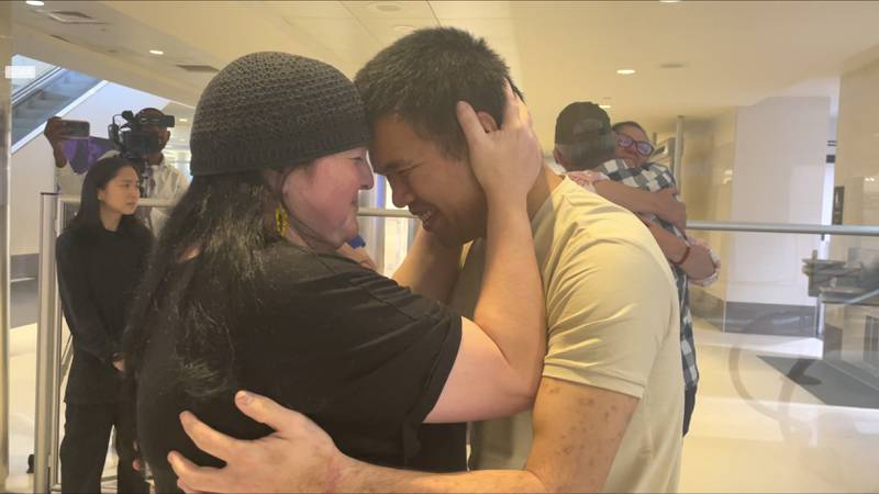 Andy Huynh, left, and Alex Drueke, far right, are seen hugging loved ones after arriving at Birmingham-Shuttlesworth International Airport in Birmingham, Ala., Saturday, Sept. 24, 2022.