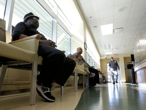 Navy veteran Samuel Ewing, left, waits to be seen by a medical care provider at the Sacramento Veterans Affairs Medical Center in Rancho Cordova, Calif., in April 2015. White House and department officials are involved in a years-long fight over privatization of VA programs and responsibilities. (Rich Pedroncelli/AP)