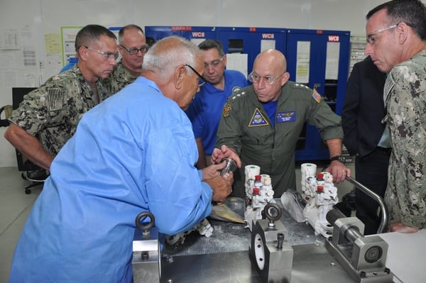 Naval Air Forces commander Vice Adm. DeWolfe Miller receives a brief on F/A-18 Super Hornet actuators Sept. 17 inside Fleet Readiness Center Southwest’s Building 472. (Christopher Nette/Navy)