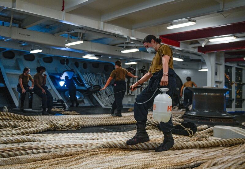 Then-Boatswain’s Mate Seaman Alexis Bias disinfects mooring line aboard the aircraft carrier Theodore Roosevelt on May 21, 2020, following an extended detour to Guam following a COVID-19 outbreak among the crew. (Navy)