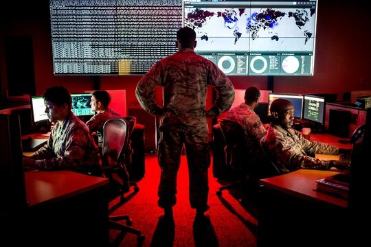 Capt. Taiwan Veney, cyber warfare operations officer, watches members of the 175th Cyberspace Operations Group, from left, Capt. Adelia McClain, Staff Sgt. Wendell Myler, Senior Airman Paul Pearson and Staff Sgt. Thacious Freeman, analyze log files and provide a cyber threat update utilizing a Kibana visualization on the large data wall in the Hunter's Den at Warfield Air National Guard Base, Middle River, Md., June 3, 2017. (U.S. Air Force photo by J.M. Eddins Jr.)