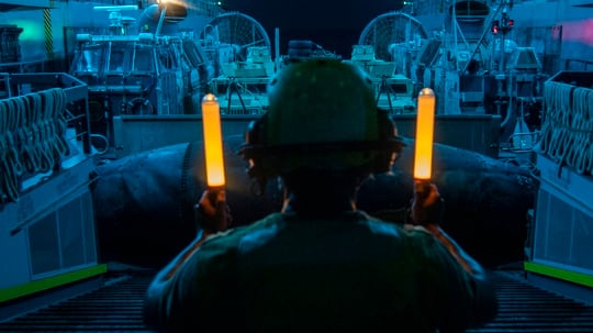 Seaman Juan Rivera signals a landing craft, air cushion Aug. 23, 2019, during well deck operations aboard the amphibious transport dock ship USS John P. Murtha (LPD 26) in the Red Sea. (Mass Communication Specialist 2nd Class Kyle Carlstrom/Navy)