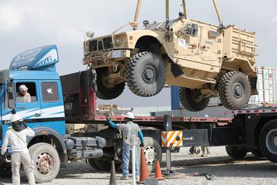 A Mine Resistant Ambush Protected vehicle is loaded on a flatbed trailer as part of the Army Field Support Battalion - Afghanistan, 10th Mountain Division Resolute Support Sustainment Brigade retrograde cargo operation on Bagram Air Field, Afghanistan, July 12, 2020.