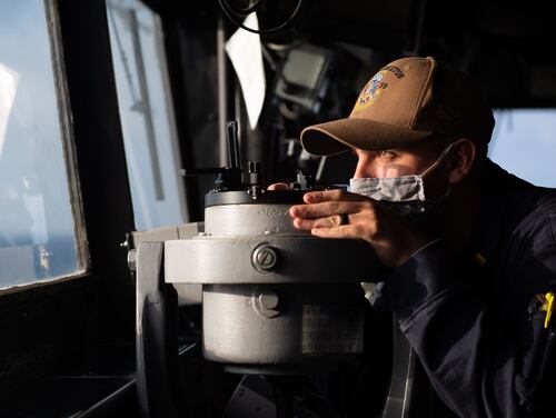 Then-Ensign Chris Luna takes a navigational bearing while standing watch in the pilot house of the guided-missile cruiser Princeton on Dec. 21, 2020, in the Indian Ocean. (Navy)