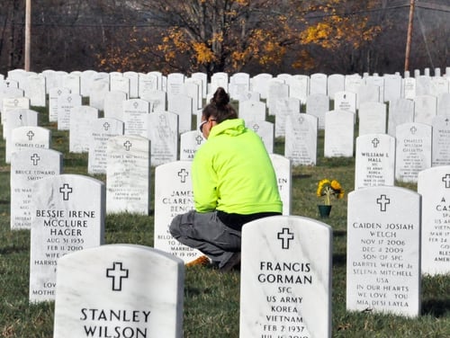 A visitor waits by a grave site at Camp Nelson National Cemetery in Nicholasville, Ky., on Nov. 11, 2015. (VA photo)