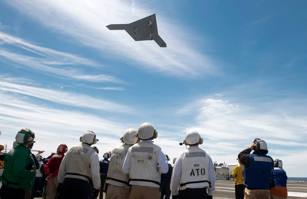 An X-47B UAV demonstrator flies over the flight deck of the aircraft carrier George H.W. Bush on May 14, 2013. The ship was the first carrier to successfully catapult-launch an unmanned aircraft from its flight deck. (MC2 Timothy Walter/U.S. Navy via Getty Images)