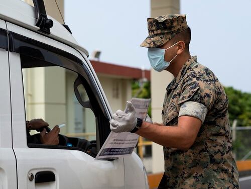 Marines conduct health and wellness checks of pool individuals entering Camp Foster in an effort to combat the spread of COVID-19, on Camp Foster, Okinawa, April 3, 2020. (Cpl. Kameron Herndon/Marine Corps)