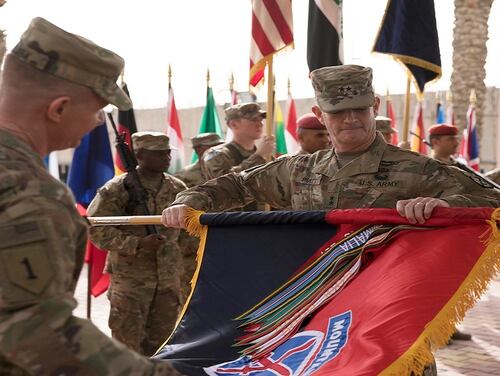 Maj. Gen. Walter Piatt, commander of the 10th Mountain Division from Fort Drum, New York, and Command Sgt. Maj. Samuel J. Roark uncase the division colors during the transfer of authority ceremony for Combined Forces Land Component Command-Operation Inherent Resolve in Baghdad, Iraq, March 19. (Staff Sgt. Michael Reinsch/Army)
