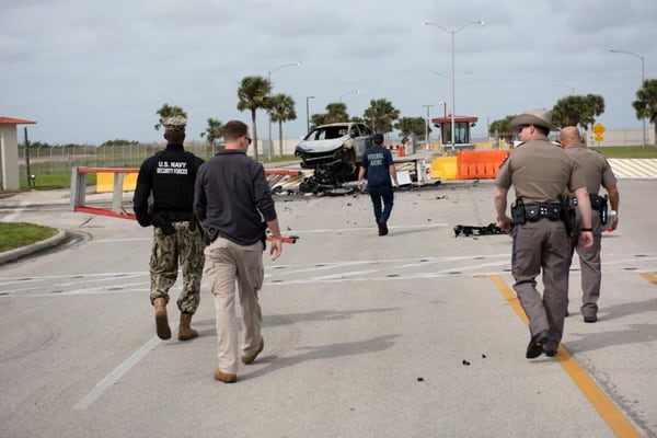 U.S. Navy Security Forces, Naval Criminal Investigative Services, and Texas Department of Public Safety survey the crash scene after a vehicle unlawfully entered the base on Thursday morning. (Anne Owens/Navy)